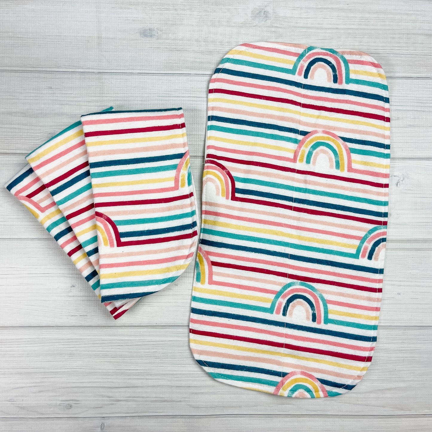 rainbow stripped flannel burp cloths. colors include: teal, navy blue, pink, coral, yellow, maroon