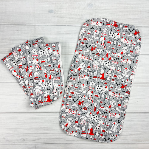 Gray flannel burpcloths with various types of dogs and bones in black, white and red. 