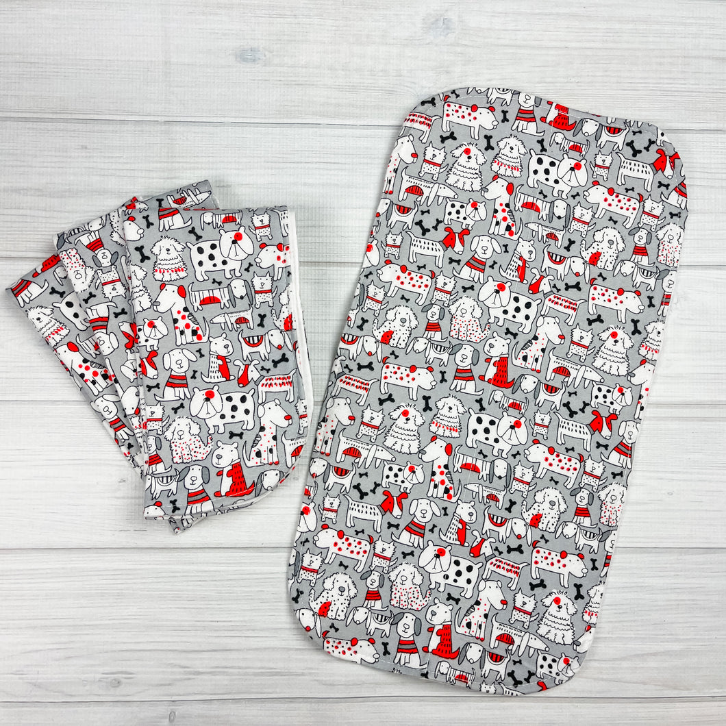 Gray flannel burpcloths with various types of dogs and bones in black, white and red. 