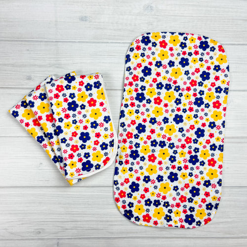 white flannel burp cloths with yellow, navy and red flowers in various sizes scattered around. 